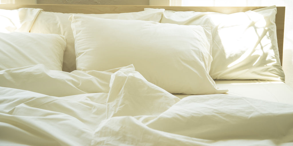 Sunlight filled bed fitted with natural color organic cotton bed sheets