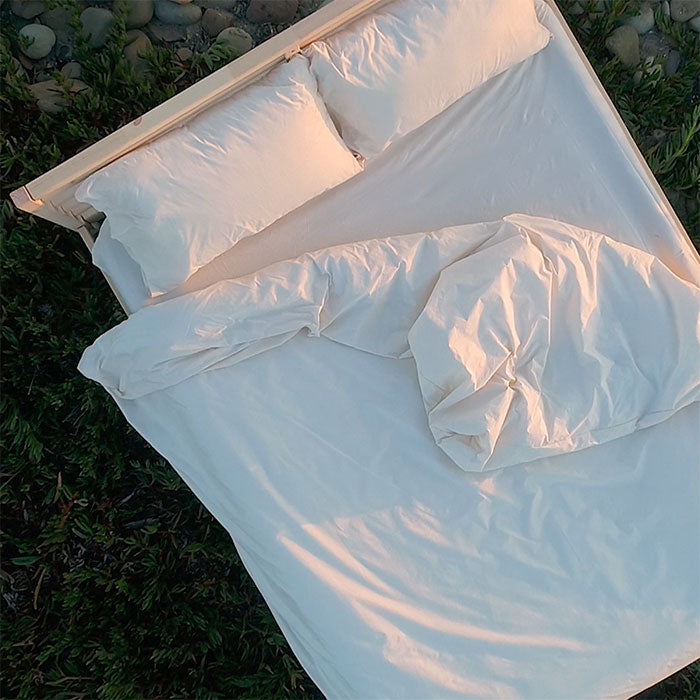Overhead view of bed on the beach at sunset