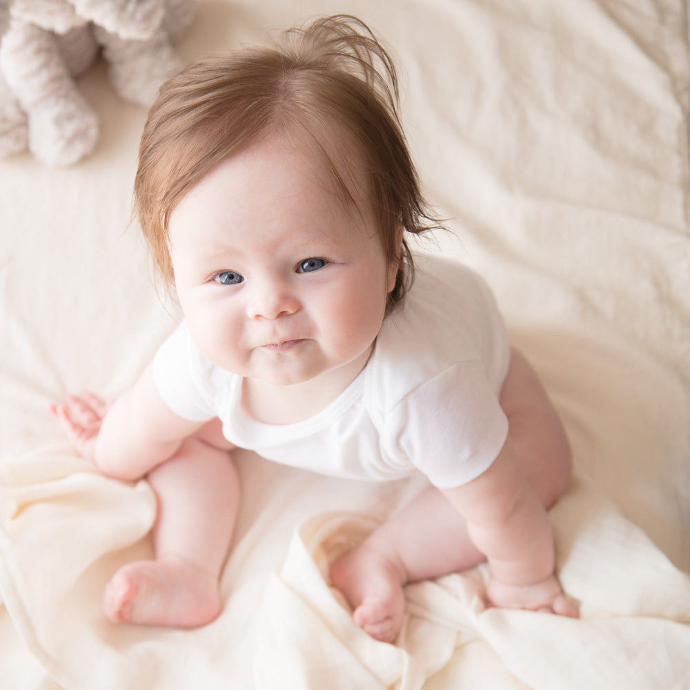 baby looking up in blaynk bed